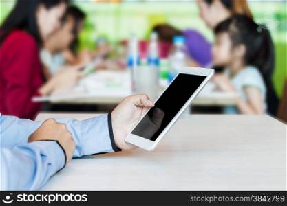 Businessman working by using digital tablet in food center