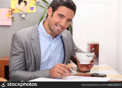 Businessman working in his kitchen with a cup of coffee