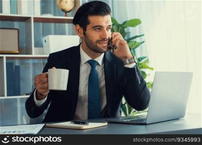 Businessman working in modern office workspace with cup of coffee in his hand while answering phone call making sales calls or managing employee. Fervent. Businessman making a sales call with clients with coffee at office. fervent