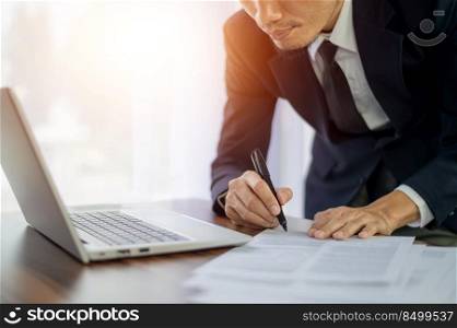 Businessman working in office and hand writing on document financial business management for business planning 2022 to 2023
