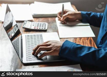 businessman working in office with using a calculator to calculate the numbers finance accounting concept