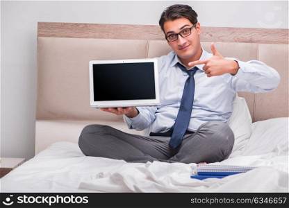 Businessman working in the bed at home