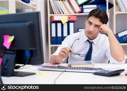 Businessman working in the office with piles of books and papers. Businessman working in the office with piles of books and papers doing paperwork