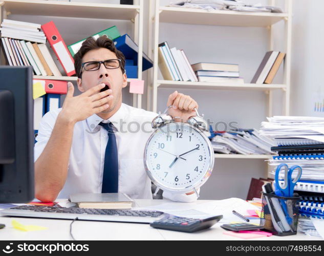 Businessman working in the office with piles of books and papers doing paperwork. Businessman working in the office with piles of books and papers