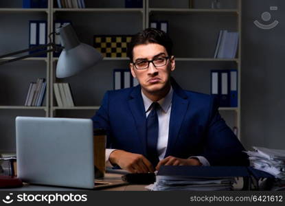 Businessman working late at night in office for overtime bonus