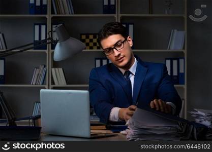 Businessman working late at night in office for overtime bonus