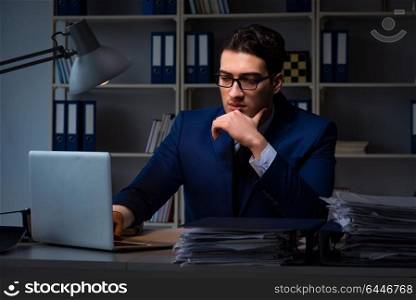 Businessman working late at night in office for overtime bonus