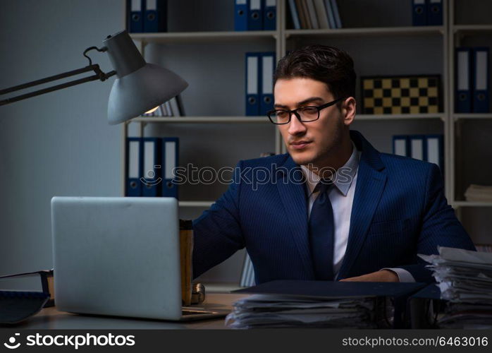 Businessman working late at night in office for overtime bonus