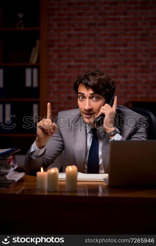 Businessman working late in office with candle light