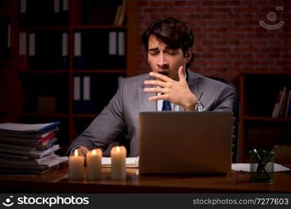 Businessman working late in office with candle light