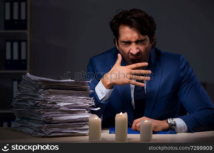 Businessman working late in office with candle light