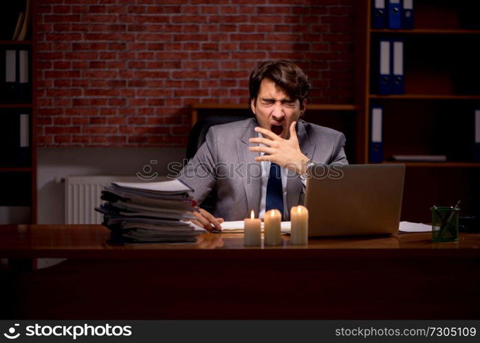 Businessman working late in office with candle light