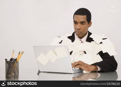 Businessman working on a laptop and covering with adhesive notes