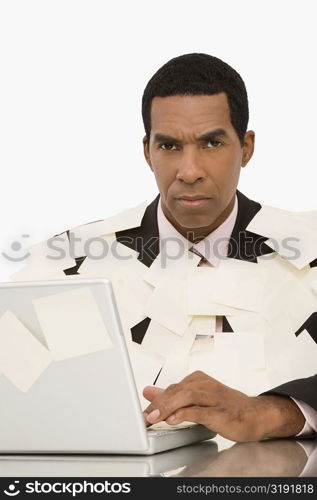 Businessman working on a laptop and covering with adhesive notes