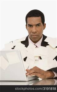Businessman working on a laptop and covering with adhesive notes