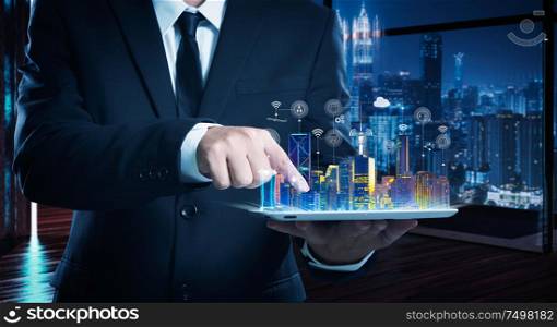 Businessman working on digital table with intelligence iot and smart city showing on virtual screen .
