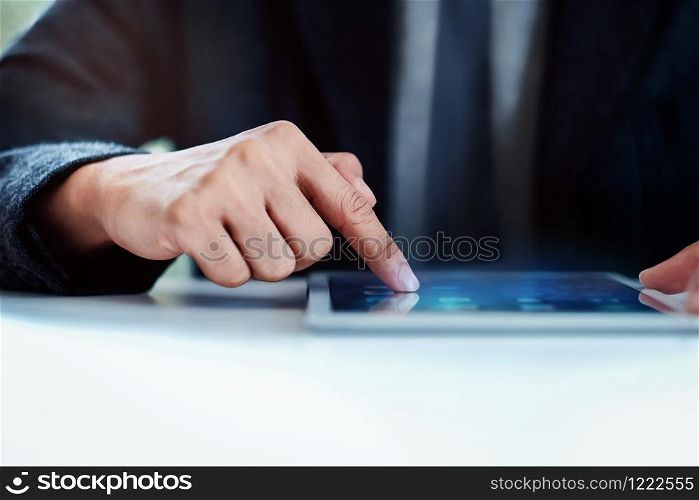 Businessman Working on Digital Tablet in Office at the Desk. Selective Focus and Cropped image