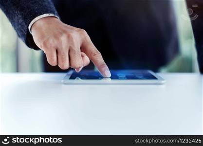 Businessman Working on Digital Tablet in Office at the Desk. Selective Focus and Cropped image