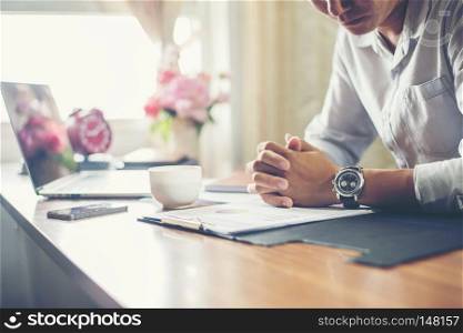 Businessman working on his desk with a cup of coffee at office.