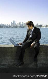 Businessman working on his laptop at a park