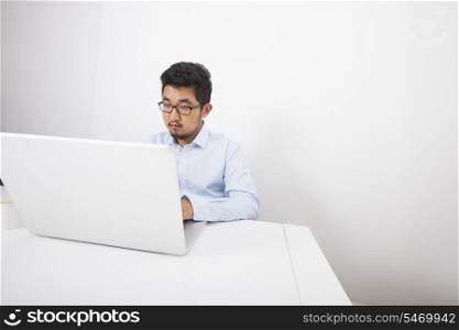 Businessman working on laptop at desk in office