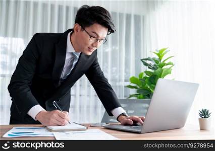 Businessman working on laptop for on office desk workspace. Smart executive researching financial business data or planning strategic business marketing with computer. Jubilant. Businessman working on laptop for on office desk workspace. Jubilant