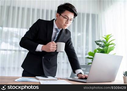 Businessman working on laptop for on office desk workspace. Smart executive researching financial business data or planning strategic business marketing with computer. Jubilant. Businessman working on laptop for on office desk workspace. Jubilant