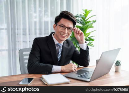 Businessman working on laptop for on office desk workspace portrait. Smart executive researching financial business data or planning strategic business marketing with computer on table. Jubilant. Businessman working on laptop for on office desk portrait. Jubilant