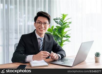 Businessman working on laptop for on office desk workspace portrait. Smart executive researching financial business data or planning strategic business marketing with computer on table. Jubilant. Businessman working on laptop for on office desk portrait. Jubilant