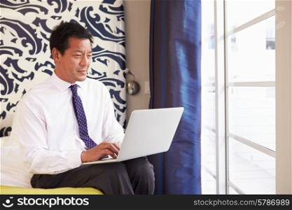 Businessman Working On Laptop In Hotel Room