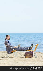 Businessman working on laptop on seaside