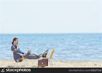 Businessman working on laptop on seaside