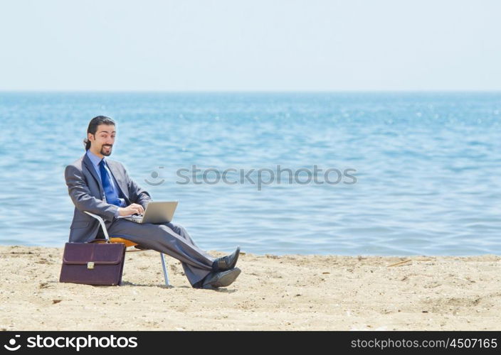 Businessman working on laptop on seaside