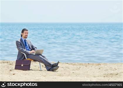 Businessman working on laptop on seaside