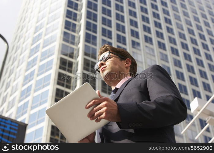 Businessman Working On Tablet Computer Outside Office