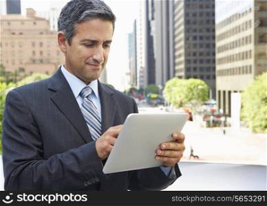 Businessman Working On Tablet Computer Outside Office
