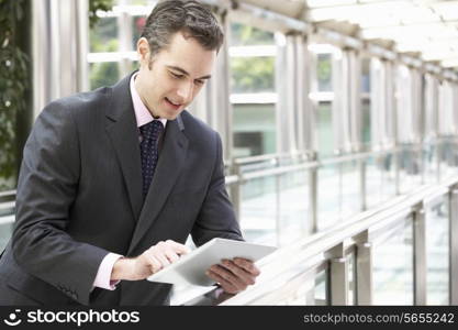 Businessman Working On Tablet Computer Outside Office