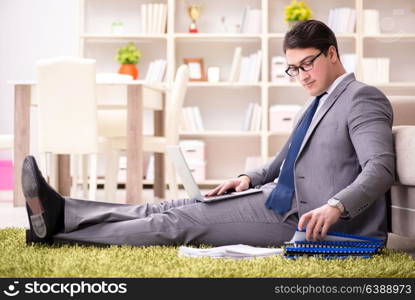 Businessman working on the floor at home