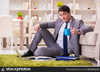 Businessman working on the floor at home