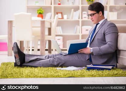 Businessman working on the floor at home