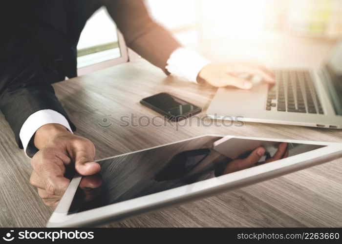 businessman working with blank screen digital tablet computer and smart phone and laptop computer on wooden desk as concept