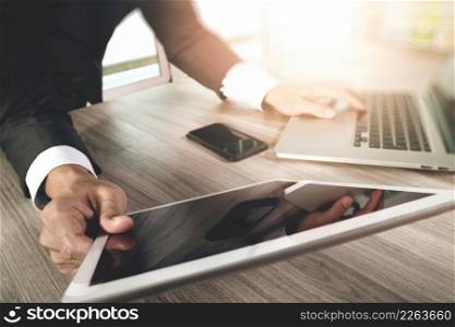 businessman working with blank screen digital tablet computer and smart phone and laptop computer on wooden desk as concept