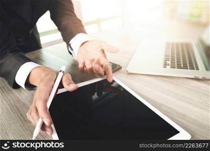 businessman working with blank screen digital tablet computer and smart phone on wooden desk as concept