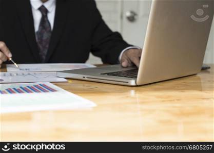 businessman working with chart diagram analysis paperwork document, laptop computer on office desk