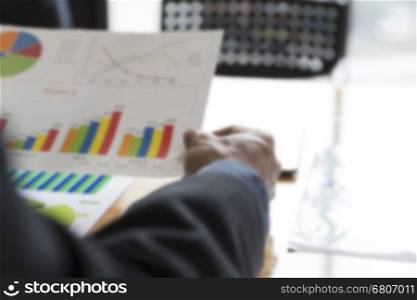businessman working with chart diagram analysis paperwork document on office desk - blur for use as background