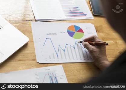 businessman working with chart diagram analysis paperwork document, tablet, laptop computer on office desk