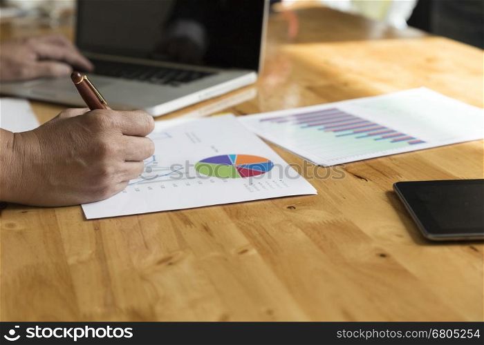 businessman working with chart diagram analysis paperwork document, tablet, laptop computer on office desk