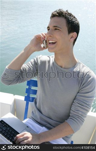 Businessman working with computer on a boat, nice outdoor office