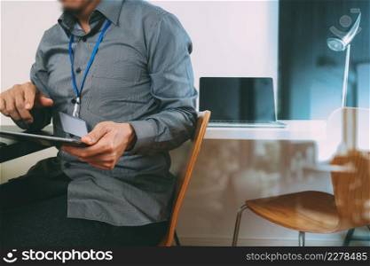 businessman working with digital tablet and laptop computer and card tag in modern office with glass reflected view