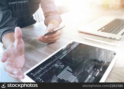 businessman working with digital tablet computer and smart phone and laptop computer with digital business strategy layer effect on wooden desk as concept